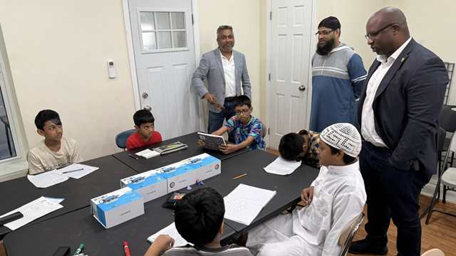 Photo : Ex-Congressman Jamal Bowman visits a classroom at Aim High Academy, engaging with students during his tour of the institution.